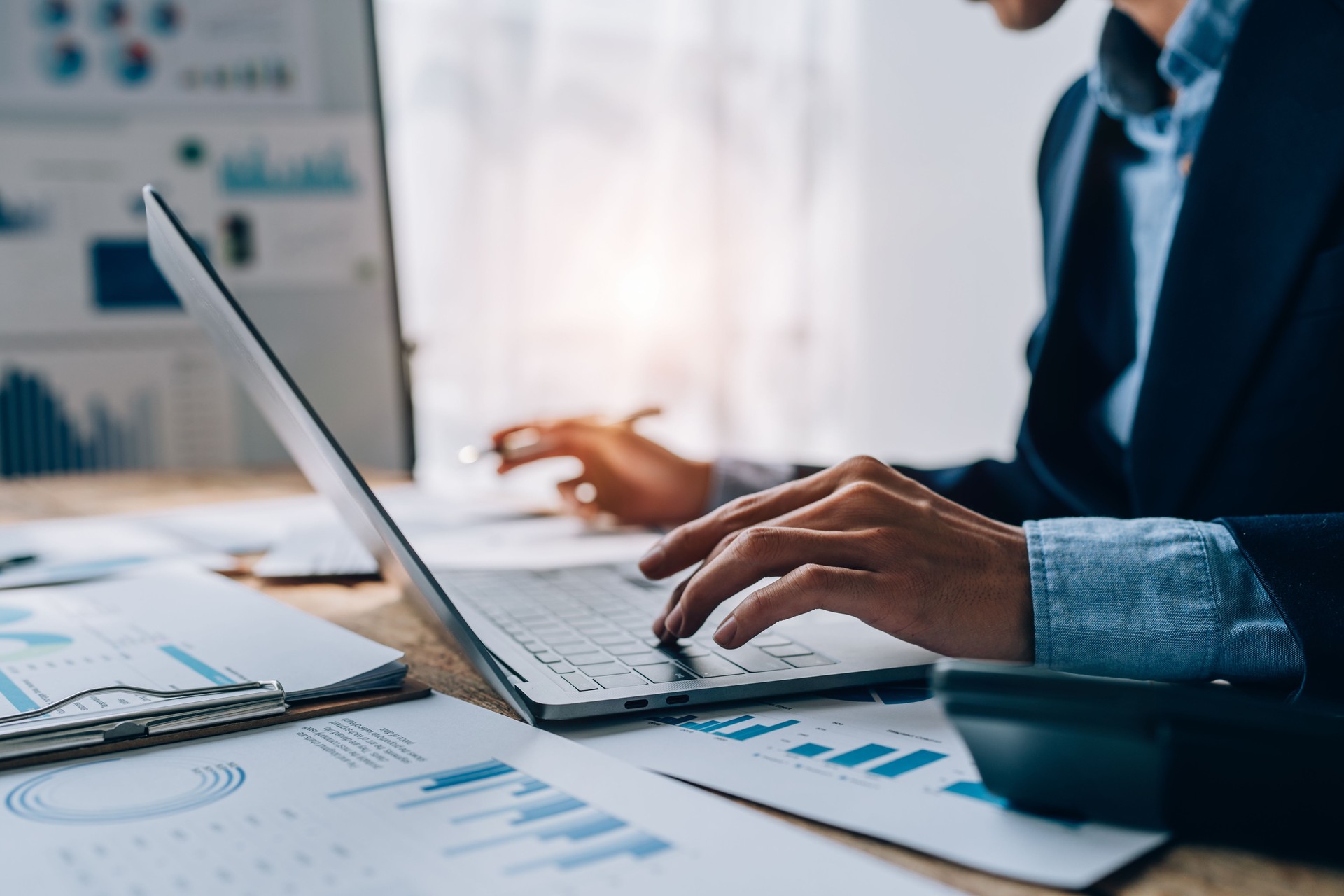 Young asian male work with financial papers at home count on calculator before paying taxes receipts online, planning budget glad to find chance for economy saving money, audit concepts.